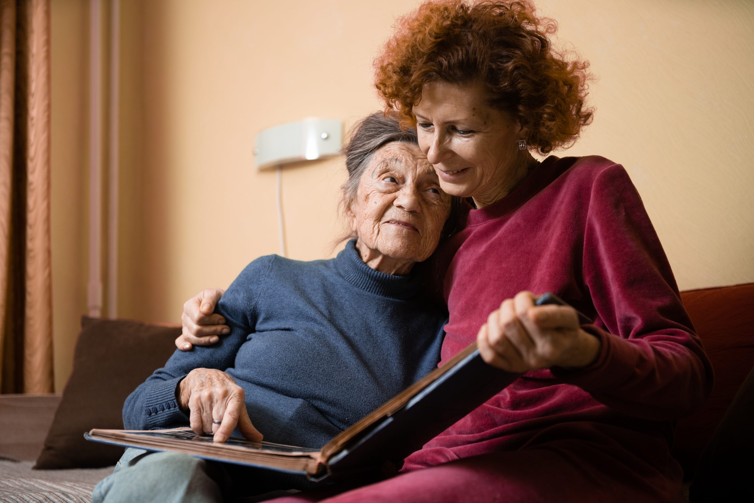 An elderly woman is consoled by a caretaker in lieu of elder mediation in Rochester NY